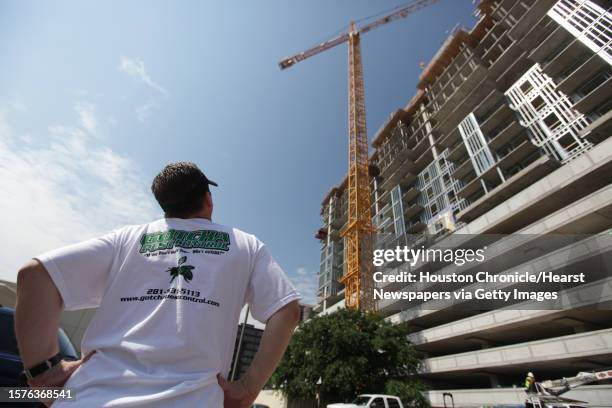 Claude Griffin, owner of Gotcha Pest Control, looks at the crane where he needs to remove bees from at a high rise under construction site along 5300...