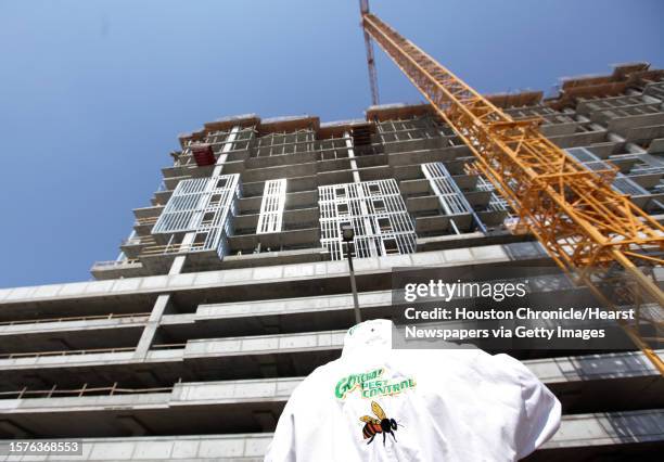 Claude Griffin, owner of Gotcha Pest Control, suits up to remove bees from a high rise under construction along 5300 block of Brownway St. In the...