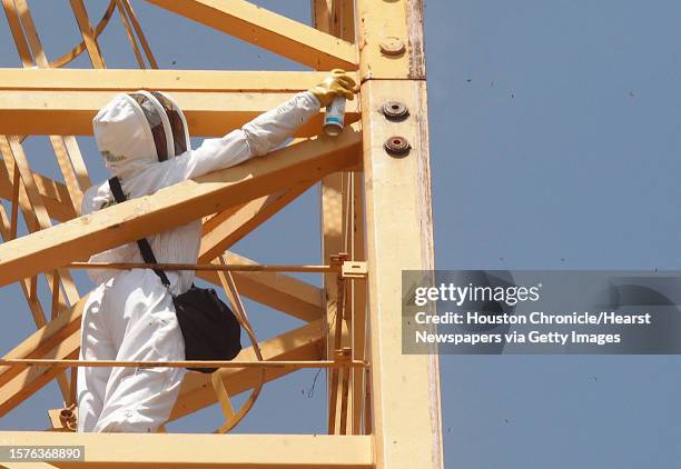 Claude Griffin, owner of Gotcha Pest Control, treats the area where honeycombs were found inside the crane connections at a high rise under...