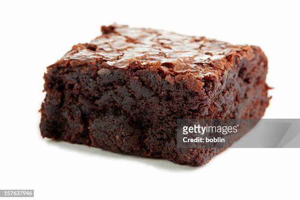 close-up of a single chocolate brownie on a white surface - brownie stockfoto's en -beelden