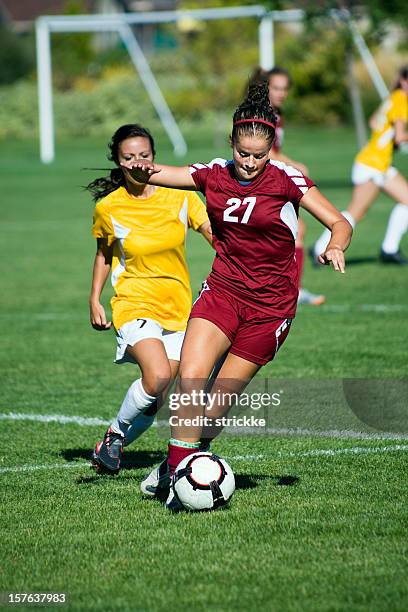 dribbling female soccer player breaks away from defense - football striker stock pictures, royalty-free photos & images