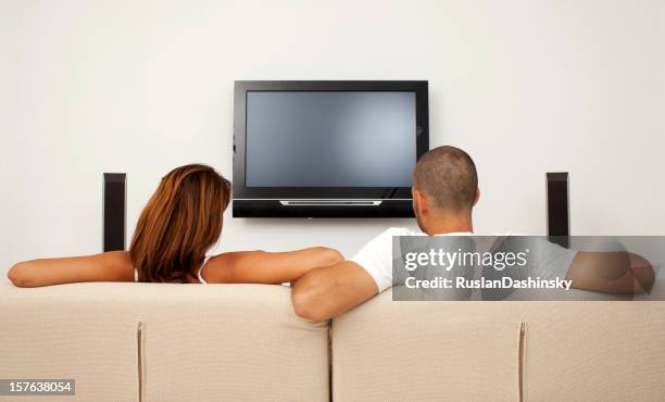 boy and girl watching tv. - back of sofa stock pictures, royalty-free photos & images