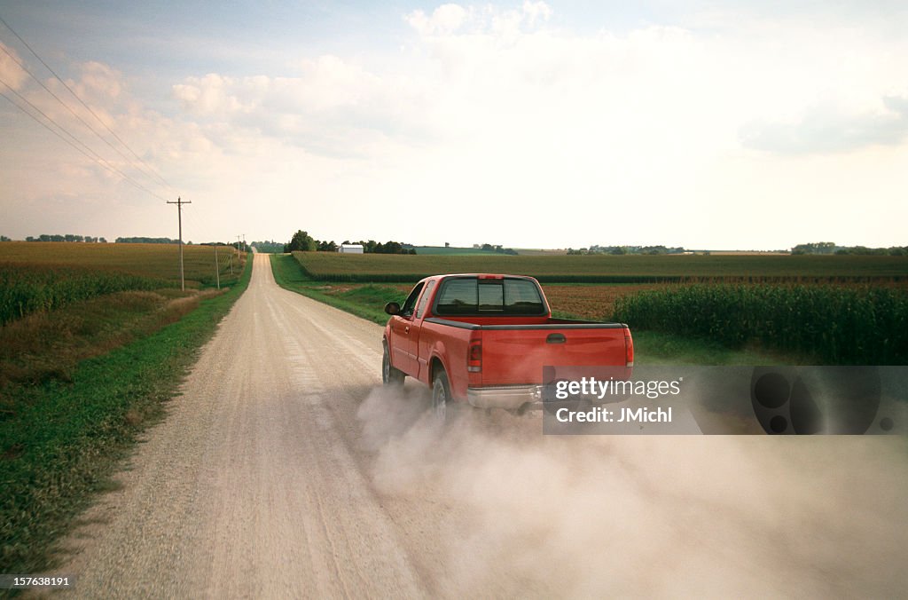 Red Pick-Up Truck Sie einen Dusty Midwest Road ab.