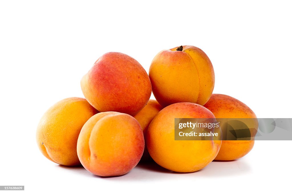 A pile of fresh apricots on a white background