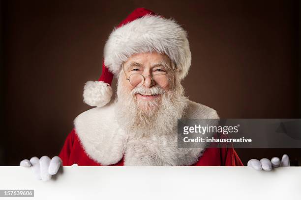 bilder von echten santa claus holding eine leere schild - santa hat stock-fotos und bilder