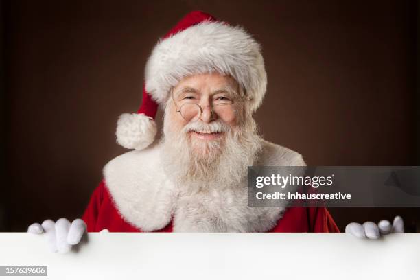 pictures of real santa claus holding a blank sign - kerstman stockfoto's en -beelden