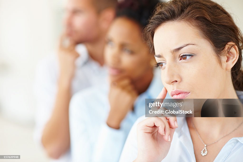 Contemplativo colegas de negocios de pie en una fila.