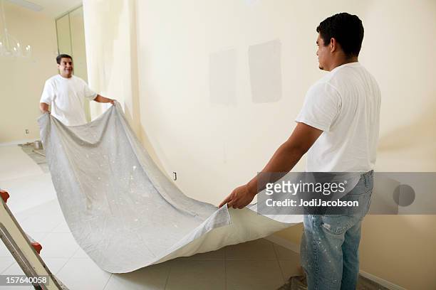 painter laying dropcloth - protective sheet stock pictures, royalty-free photos & images