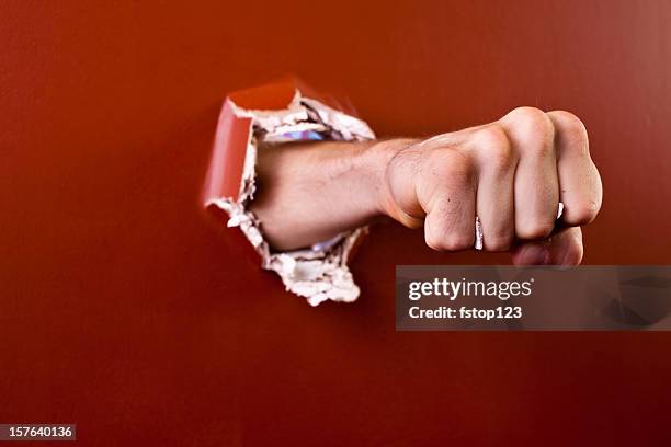 hombre en puño que pasa a través de la pared. - puñetazo fotografías e imágenes de stock