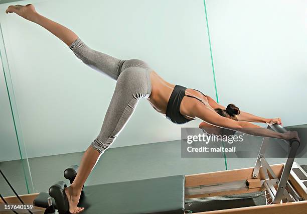 woman doing pilates exercises in the gym - reformer stock pictures, royalty-free photos & images