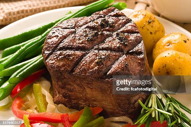 a well cooked filet of mignon served with asparagus - filet mignon stock pictures, royalty-free photos & images