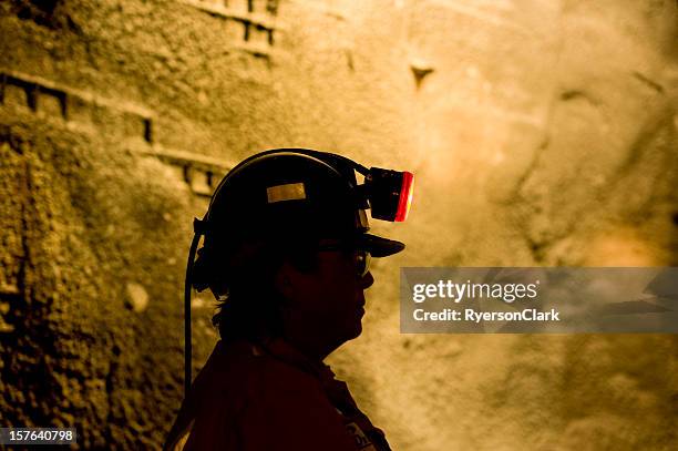 woman underground mine worker with lamp on. - miner stockfoto's en -beelden