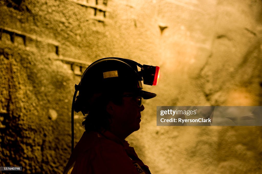 Woman Underground Mine Worker with Lamp On.