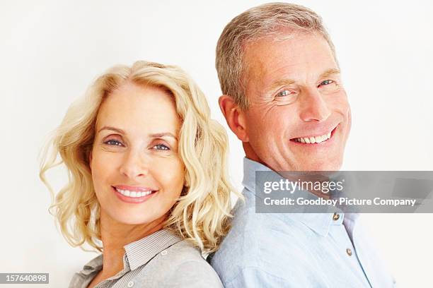 smiling couple against white background - 55 60 years stock pictures, royalty-free photos & images