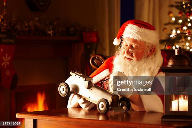 father christams painting a toy car in his workshop - santas workshop stock pictures, royalty-free photos & images