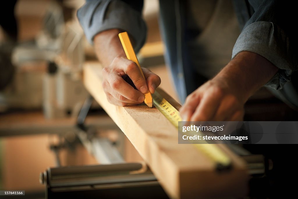 Carpenter medir un tablón de madera