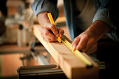 Carpenter Measuring a Wooden Plank