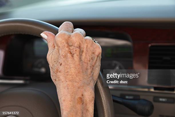 senior woman hand on steering wheel - liver spot stock pictures, royalty-free photos & images