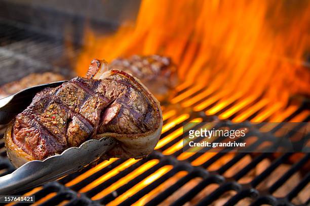 filet mignon im speckmantel rindfleisch auf dem grill mit flammen mit tanz - vom holzkohlengrill stock-fotos und bilder