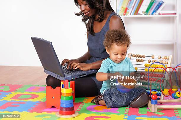 una empresaria afroamericana trabajando mientras su hijo tiene - abacus computer fotografías e imágenes de stock