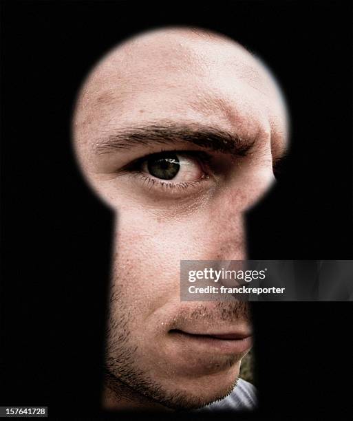 discover something through lock door keyhole - curious man - ergens doorheen kijken stockfoto's en -beelden