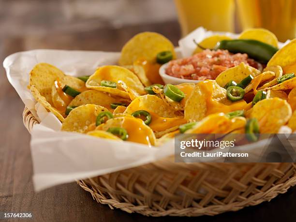 nachos com molho de queijo, jalapeños e cervejas - nachos - fotografias e filmes do acervo