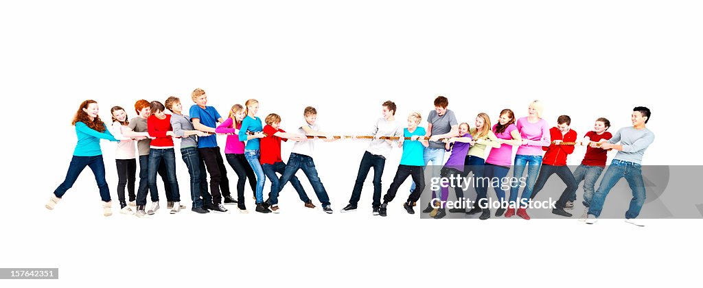 A group of teenage boys and girls playing tug of war