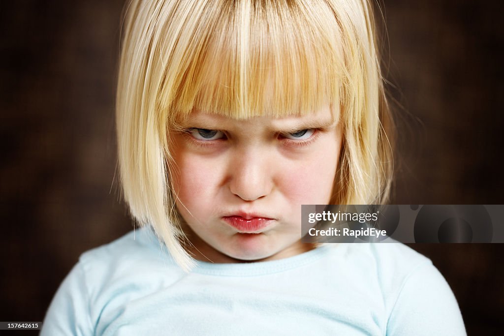 Linda rubia Chica niño scowls a la cámara