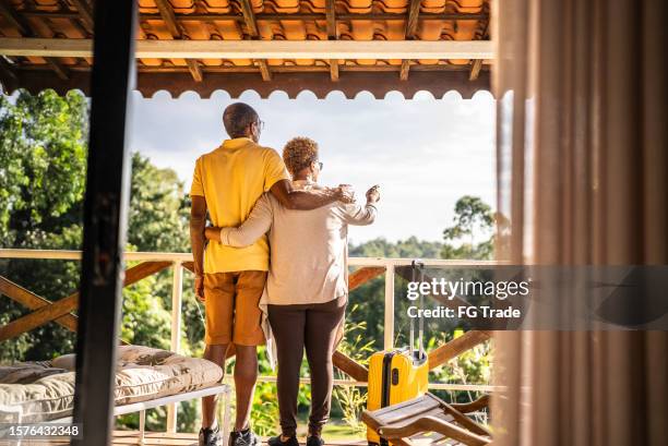 pareja mayor mirando hacia otro lado y relajándose en el balcón del hotel - hotel rural fotografías e imágenes de stock