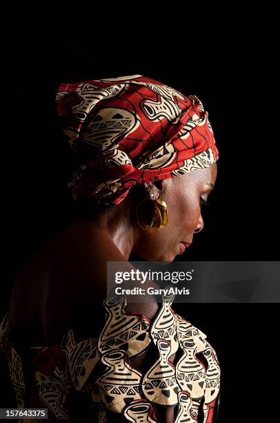 3/4 de vista de expressivo africano mulher em traje tradicional e olhando para baixo - artigo de vestuário para cabeça - fotografias e filmes do acervo