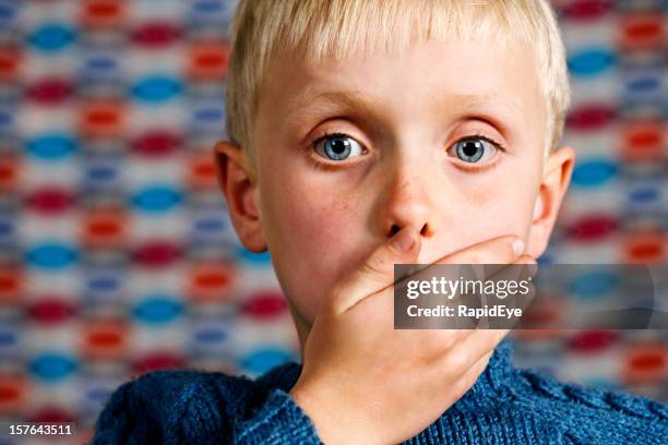 blond boy makes the 'speak no evil' gesture - grief hands stock pictures, royalty-free photos & images