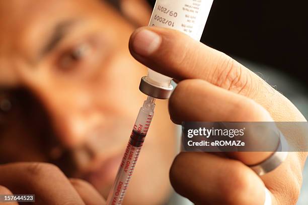 a male loading insulin into a needle - insulin bildbanksfoton och bilder