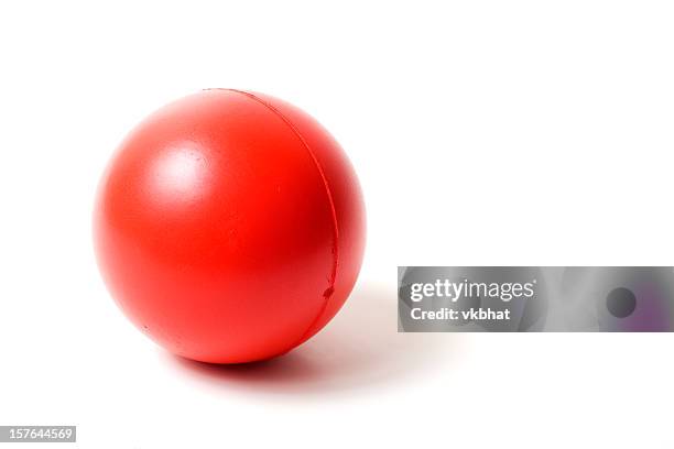 close-up of a red rubber stress ball on white background - stress ball stock pictures, royalty-free photos & images