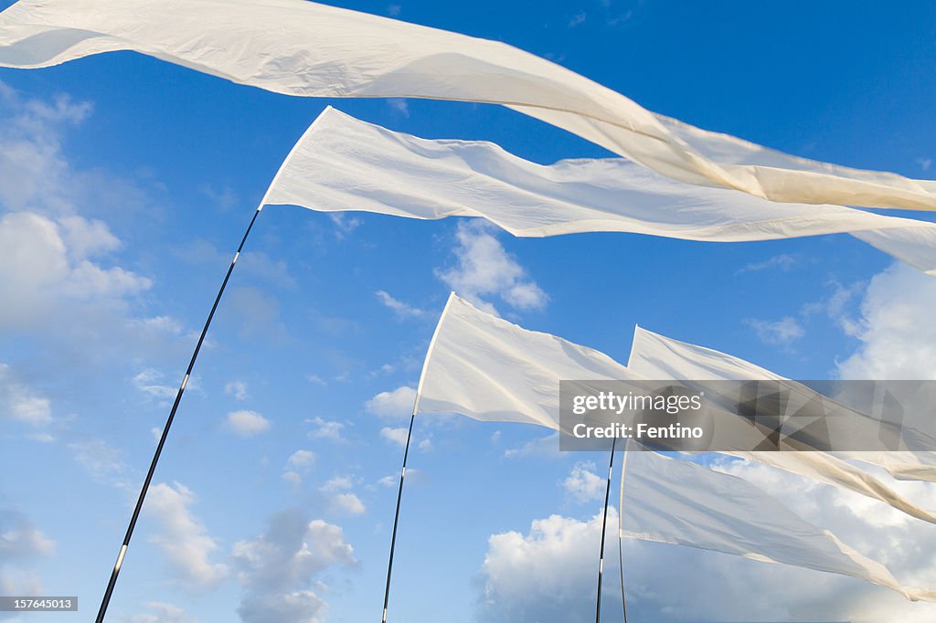 Weiße Flags vor blauem Himmel