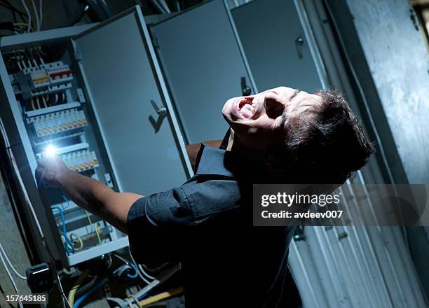 man getting shocked by electricity on a breaker - electrical shock stockfoto's en -beelden