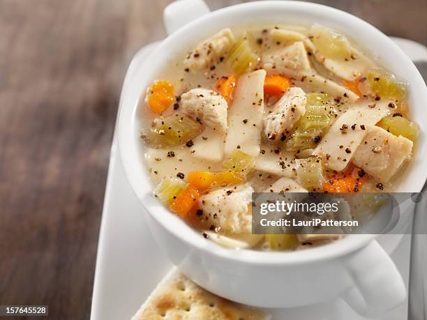 chunky chicken noodle soup with saltine crackers - chicken noodle soup stock pictures, royalty-free photos & images