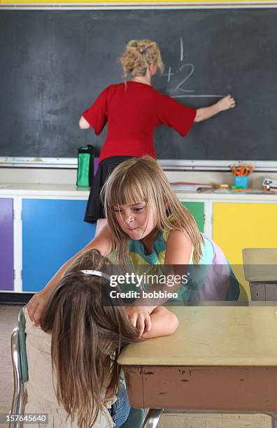little girls fighting behind teachers back - class argument stockfoto's en -beelden