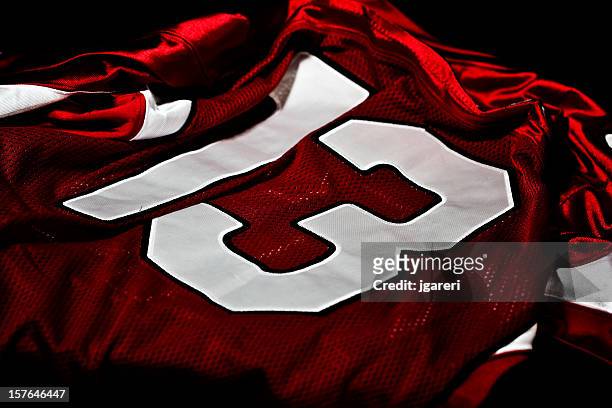 dark red and white jersey with the number thirteen on it - american football uniform stock pictures, royalty-free photos & images