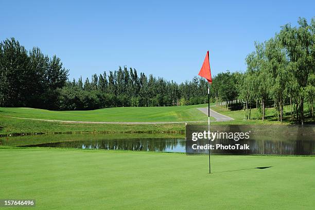 golf grün und rote flagge-xl - golfplatz stock-fotos und bilder