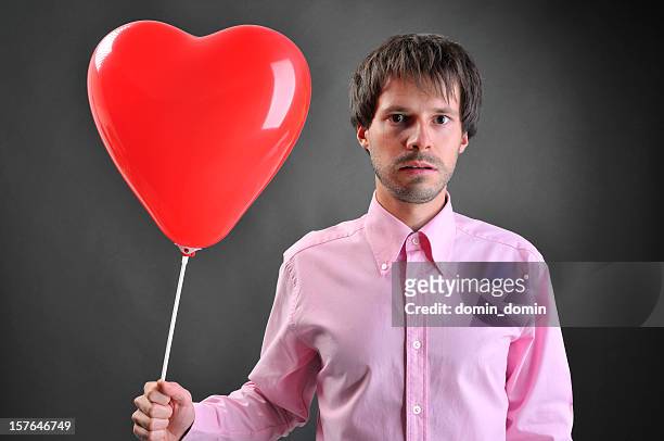 lonely, lost man with red, heart-shaped balloon looking for love - defeat fear stock pictures, royalty-free photos & images
