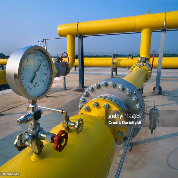 manometer on yellow pipes in a gas distribution station - methaan stockfoto's en -beelden