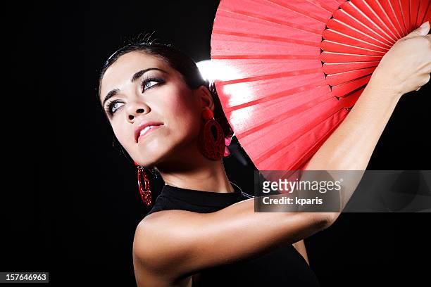 flamenco dancer with red hand fan looking into the distance - flamencos stock pictures, royalty-free photos & images