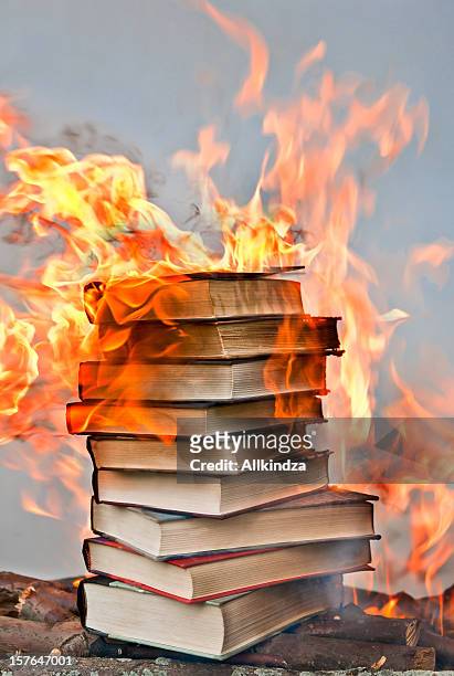 stack of hardcover burning books - exclusion stock pictures, royalty-free photos & images
