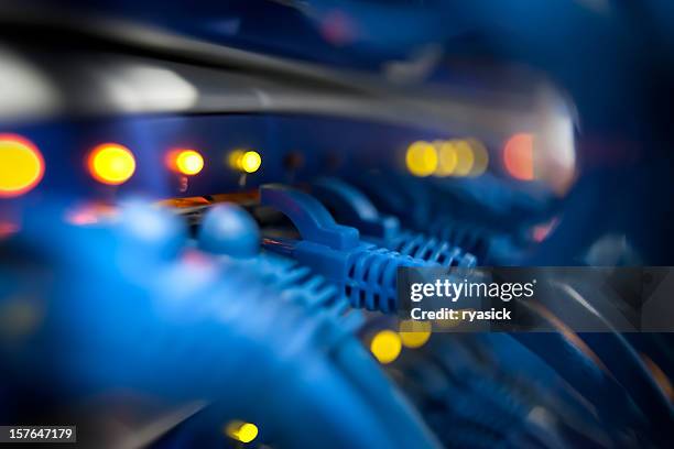 closeup of a server network panel with lights and cables - elektronica stockfoto's en -beelden