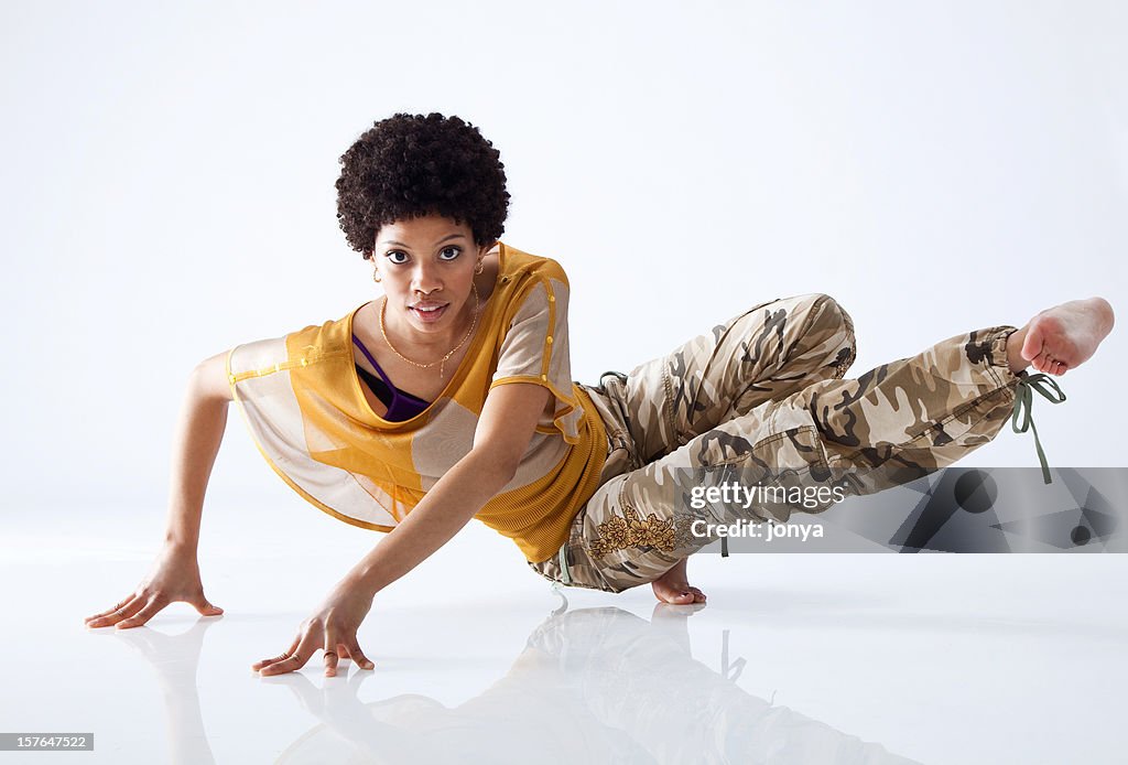 Female hip hop dancer mid move with all white background