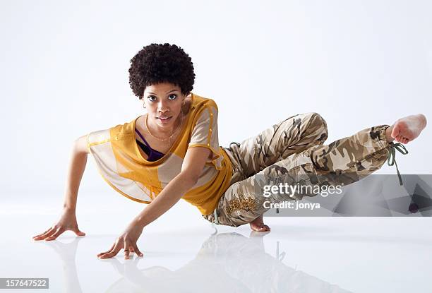 female hip hop dancer mid move with all white background - break dancer stock pictures, royalty-free photos & images