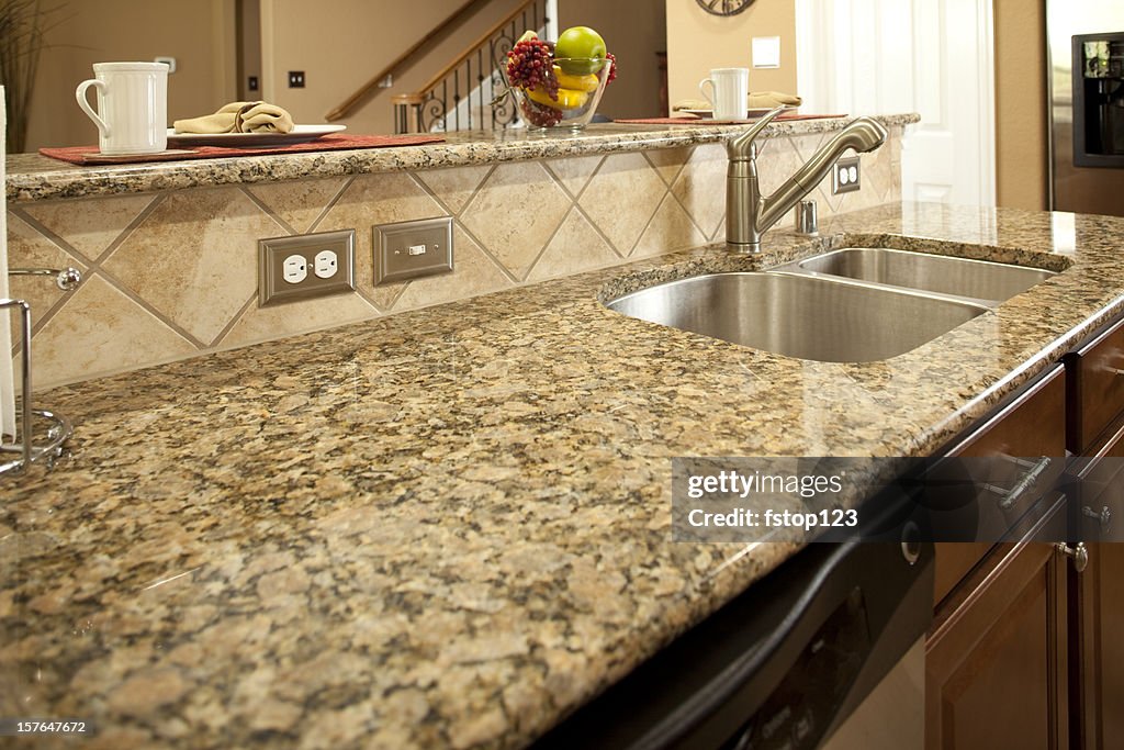 Granite kitchen counter with dishwasher underneath. Sink. Bar.