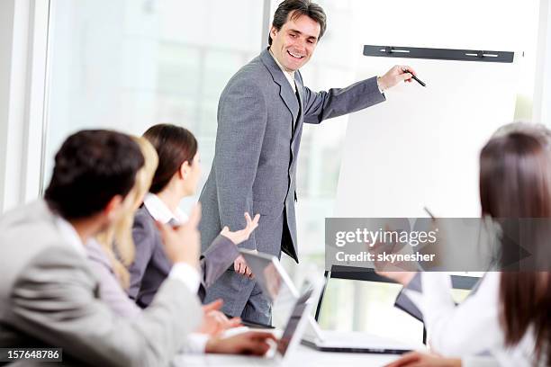 business man showing plan of work at the flipchart. - gray suit stock pictures, royalty-free photos & images