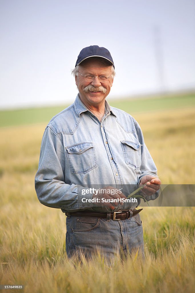 Older man in blue shirt standing in field