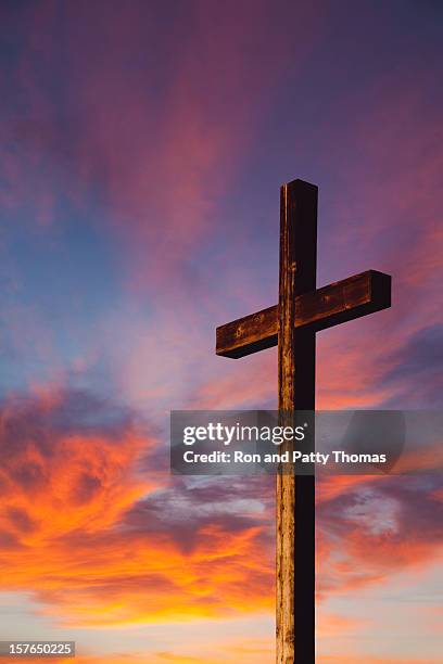 rugged wooden cross against sunset sky - crucifix shape stock pictures, royalty-free photos & images